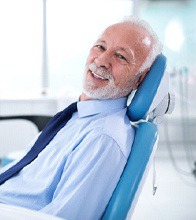 Older man with dental implants in Blaine smiling at dentist.