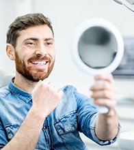 man seeing his new smile after visiting his cosmetic dentist in Blaine 