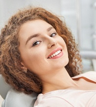 Woman leaning back in dental chair for gum disease therapy in Blain, MN