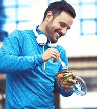 a man with dental implants eating healthy food