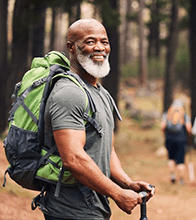 a mature man with dental implants hiking with friends