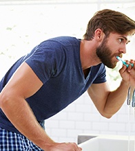 man brushing his teeth  