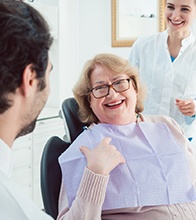 Patient smiling with dental assistant and implant dentist in Blaine.