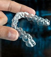 person holding Invisalign aligner 