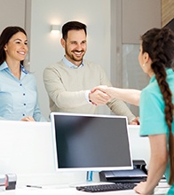 dental team member shaking patient’s hand 