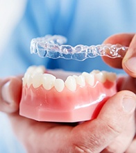Dentist in Blaine placing Invisalign on model of teeth