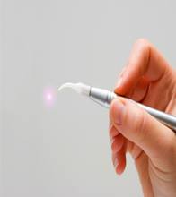 Hand holding a laser dentistry tool