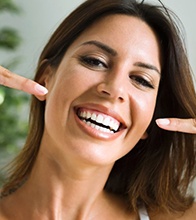 Woman pointing to veneers in Blaine