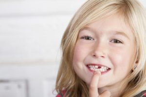 little girl pointing at missing tooth