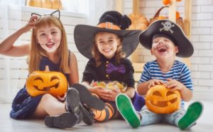 three kids in Halloween costumes