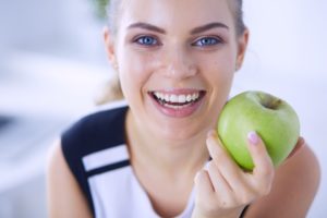 smiling woman holding an apple
