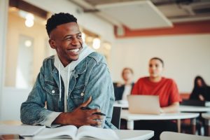 Teenage student sitting in the classroom and smiling.