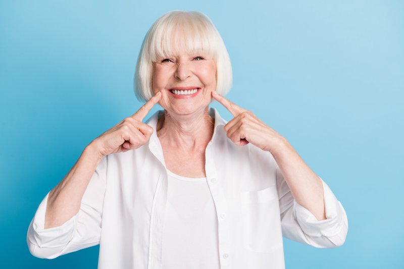 An older woman smiling with her dentures