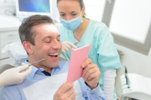 Man smiling after getting his permanent veneers placed